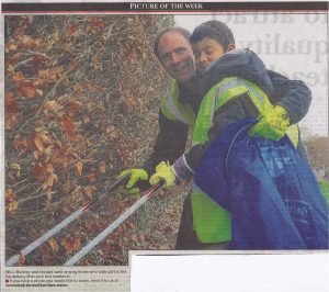 Father and son picking up litter