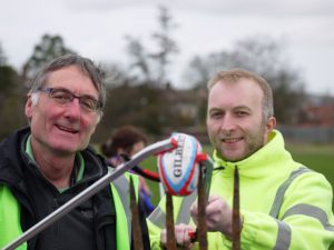 Two councillors with a rugby ball and pitchfork